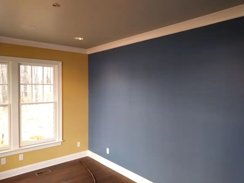 Navy accent wall meeting a gold wall under white crown moulding