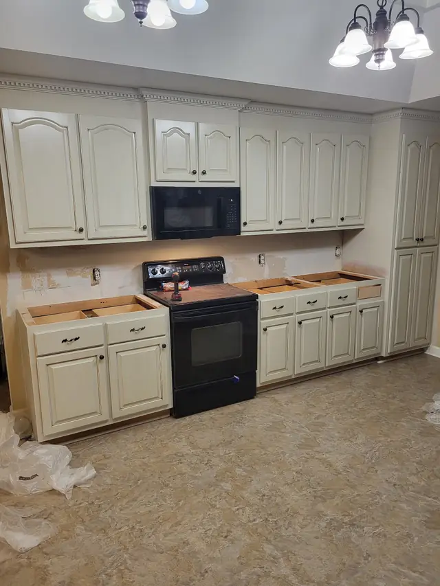 Kitchen cabinets refinished in antiqued cream with the countertops removed